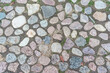 © Bonsales - Cobbles stones close up and green grass in it seams on urban cobblestoned pavement, overhead view