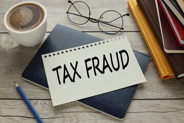 Wall Mural - Tax Fraud. glasses lie near a cup of coffee. text on a notebook