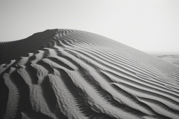 Poster - A monochrome photograph of a sand dune. Suitable for various uses