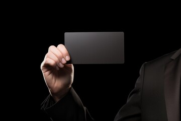 Poster - A professional man in a formal tuxedo holding a business card. This image can be used to portray professionalism, networking, or business interactions