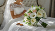 Bukiet i obrączki leżące na łóżku, w tle panna młoda przygotowująca się do ślubu