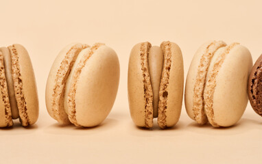 Wall Mural - Chocolate macarons on a beige background, dessert