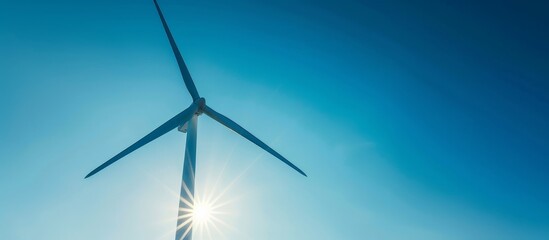 Wall Mural - Wind turbine with three blades seen against a clear blue sky in the foreground.