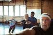 © Davor - Fitness instructor or trainer helping a group of seniors exercise and workout in the gym