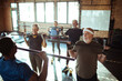 © Davor - Fitness instructor or trainer helping a group of seniors exercise and workout in the gym