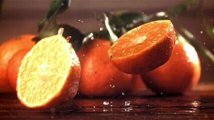 Wall Mural - A tangerine breaks into two halves when it falls. Filmed on a high-speed camera at 1000 fps. High quality FullHD footage