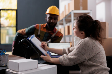 Wall Mural - Storehouse manager signing inventory report, discussing products quality control during storage room inventory. Diverse stockroom employees working at clients online orders in warehouse