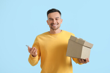 Sticker - Happy young man with gift on blue background