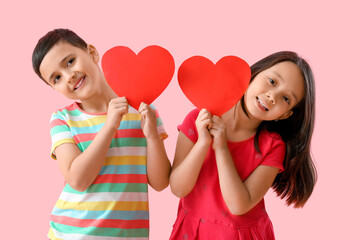 Wall Mural - Cute little children with red hearts on pink background. Valentine's Day celebration