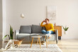 © Pixel-Shot - Young man sitting on couch in living room