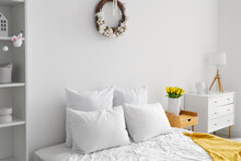 Interior Of Light Bedroom With Easter Wreath And Tulips