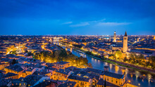Spectacular Night View Of Historic Verona Town With The Adige River, Brilliant City Lights And Deep Blue Sky Seen From Castle San Pietro In Verona, Italy