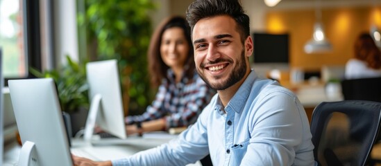 Canvas Print - Smiling young businessman and colleague working on computer at office in portrait.