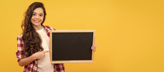 Poster - happy kid pointing finger on school blackboard for copy space, education. Banner of school girl student. Schoolgirl pupil portrait with copy space.