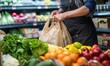 environmentally friendly movement. grocery store cashier packing food into a reusable bag 