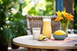 outdoor setting with mango lassi on a sunny table with tropical plants