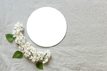 Sticker - White circle with a white flowers on a gray background. Flat lay, top view. Happy mother's day, women's day or birthday, wedding composition.