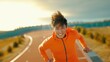 Young asian runner man in bright orange sporty jacket running in the morning smiling at camera with toothy smile active and healthy lifestyle concept