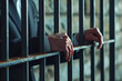 Man hold hand on steel lattice at jail