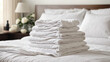 White folded terry towels lie on clean white bed. Cleaning in guest room of hotel, cleanliness, laundry