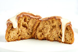 Fototapeta  - A cinnamon roll is poured with custard and sprinkled with cinnamon on a white background.