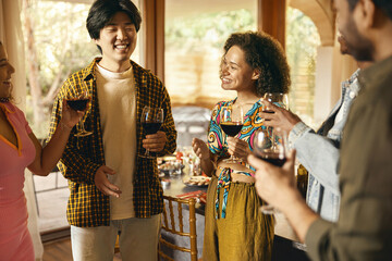 Wall Mural - Happy friends enjoying in conversation and drinking wine during festive dinner at home party