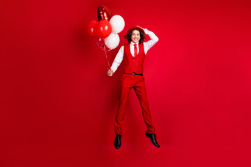 Poster - Full body length photo of youngster gentleman with beautiful flying air balloons jump to the party isolated on red color background