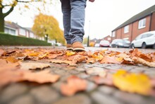 Perspective Of Walking On A Pavement Covered With Autumn Leaves