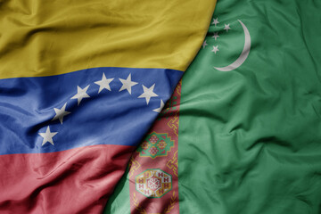 big waving national colorful flag of turkmenistan and national flag of venezuela . macro