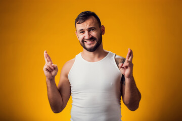 Man showing crosses fingers gesture, anticipate hearing good news. Excitement concept