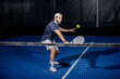 © homydesign - Padel player hitting ball with a racket
