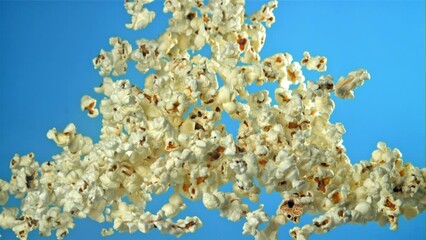 Sticker - Popcorn flies up and falls down. On a blue background. Filmed on a high-speed camera at 1000 fps. High quality FullHD footage