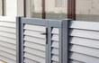 Modern stone fence with aluminum or metal shutter
