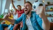© CraftyImago - Group of friends cheering on a football match in the living room are celebrating their team's goal.