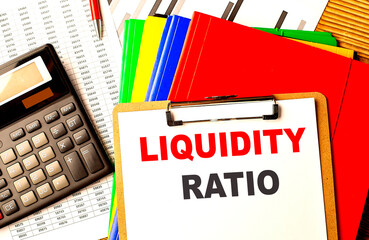 Poster - LIQUIDITY RATIO text written on paper clipboard with chart and calculator