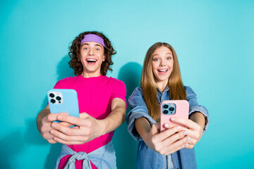 Sticker - Photo of two funny happy brother and sister takes selfie pictures themselves holding phones smiling isolated on cyan color background