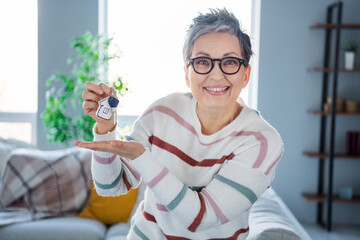 Sticker - Photo of pretty cheerful person toothy smile hand hold showing new house key bright modern interior inside