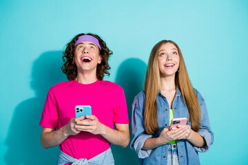 Sticker - Photo of family young teenagers boyfriend girlfriend use phone look above head amazed social medias info isolated on cyan color background