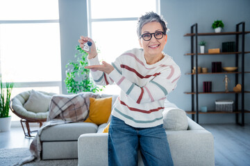 Canvas Print - Photo of positive friendly grandmother hand hold demonstrate new house key spacious interior indoors