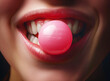 Close-up of a girl blowing a vibrant pink bubblegum bubble, with glossy lips and white teeth.