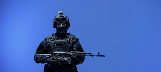 Wall Mural - Soldier in black uniforms with weapon gun in studio. Banner Military army concept