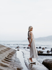 Poster - Sunny Beach Escape: A Free Spirit Embraces the Ocean's Beauty in a White Dress, Feeling Attractive and Relaxed amidst the Tropical Paradise.