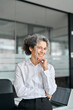 © insta_photos - Smiling middle aged business woman leader standing in office, vertical portrait. Happy older mature female corporate manager, confident senior lady executive or entrepreneur posing at work.
