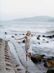 Canvas Print - Serene Beauty: A Young Woman's Blissful Vacation on a White Sandy Beach at Sunset