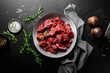 Beef meat entrecote sliced, raw beef meat fillet on black background, top view