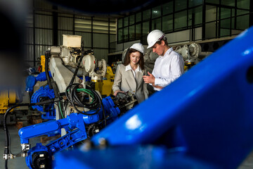 Robot engineer man and woman workers working together in robotic inventory factory 