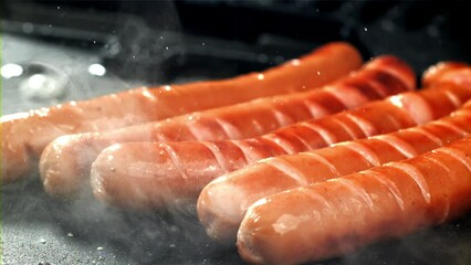 Canvas Print - Sausages are fried with splashes in a pan. Filmed on a high-speed camera at 1000 fps. High quality FullHD footage