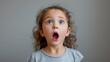 © Wendy2001 - Shocked or surprised brown hair Four year old little girl with two in awe left speechless with his eyes and mouth wide open on neutral gray background