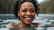 Close-up of a middle-aged, attractive black woman with a beaming smile, enjoying a soak in a natural hot spring with a scenic mountain backdrop, exuding relaxation and happiness.