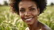 Close-up of a middle-aged, attractive black woman with curly hair and a warm smile, outdoors with blurred greenery in the background, showcasing radiant skin and natural beauty.